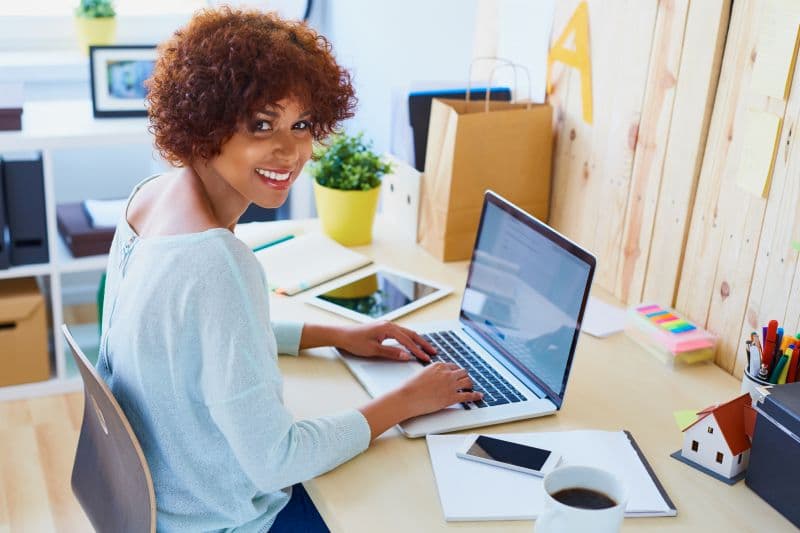 Young female designer working on laptop in office